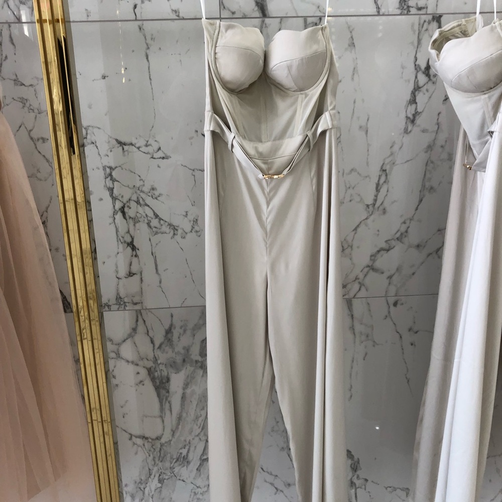 Oyster strapless jumpsuit with a gold belt.